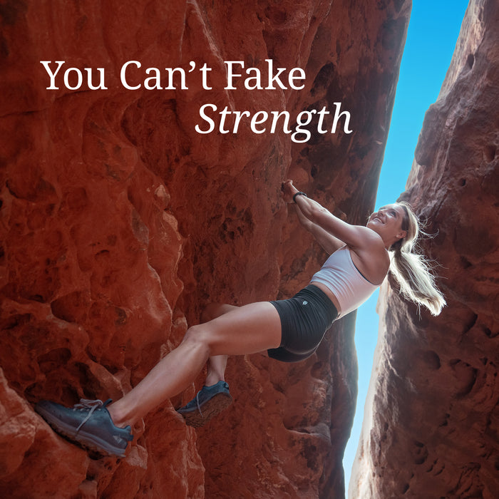 Woman climbing a narrow red rock canyon under blue sky with text 