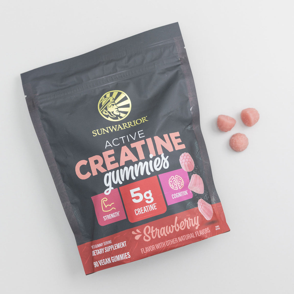 Sunwarrior Active Creatine gummies pouch with strawberry flavored pink gummies beside it on white background