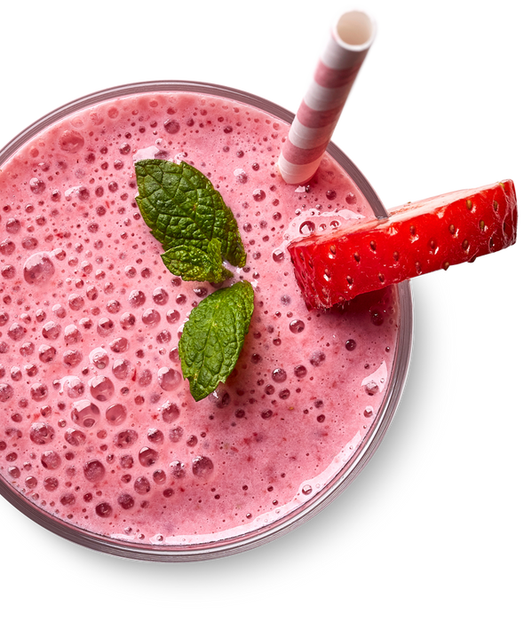 A pink strawberry smoothie in a clear glass with a pink-and-white striped paper straw, garnished with two mint leaves and a strawberry slice, on a white background.
